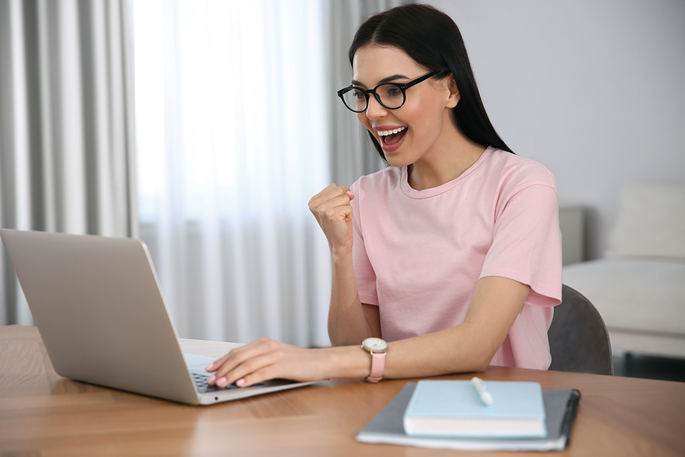 Freudige Frau am PC